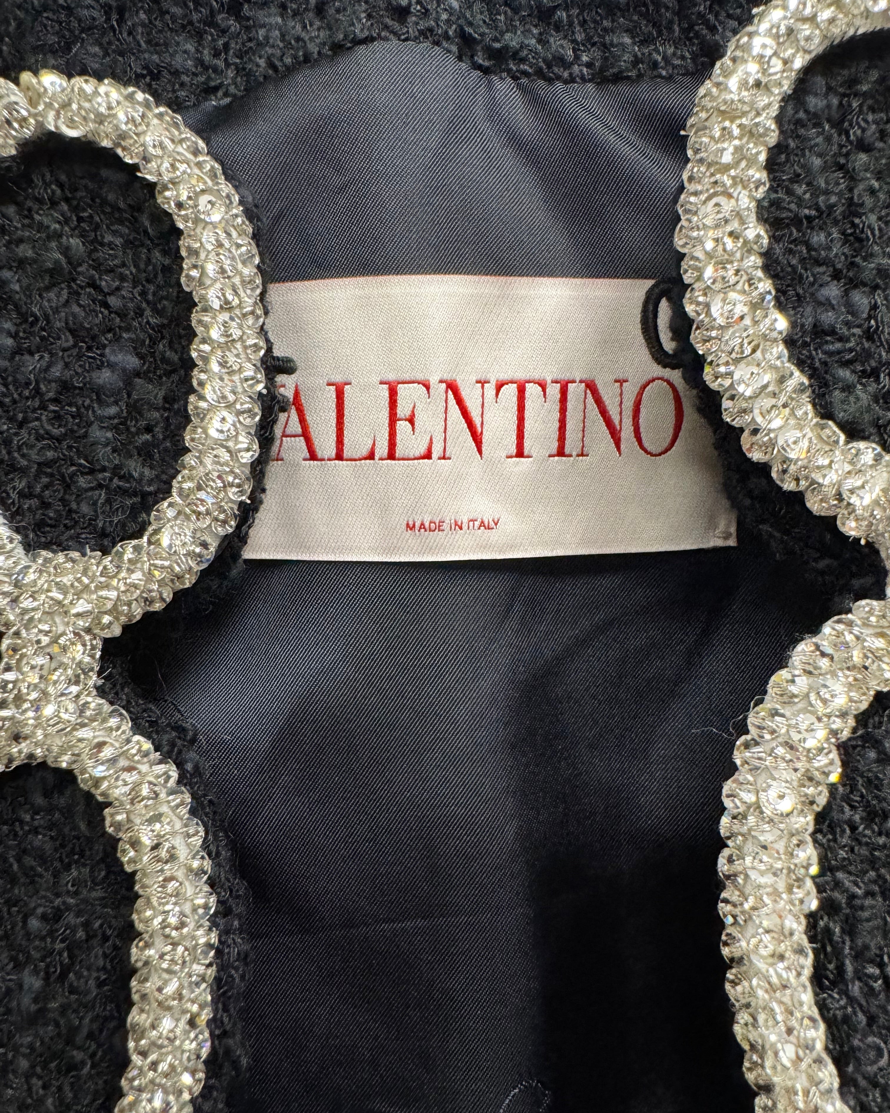 Valentino label on a black garment with decorative silver frames.