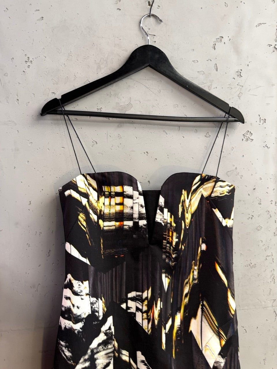 BERLIN VINTAGE CORNER sleeveless midi cocktail dress with abstract black, white, and gold print and deep V-neckline.