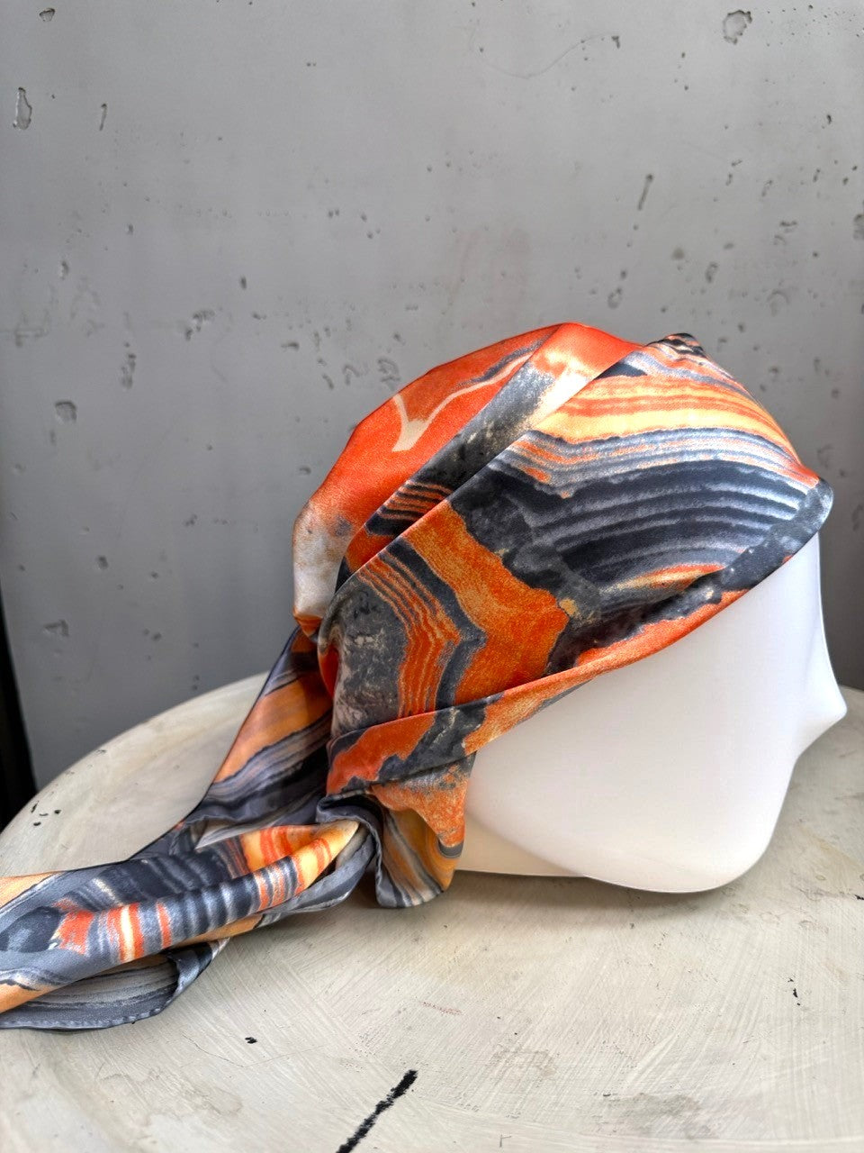 BERLIN VINTAGE CORNER silk scarf with a burnt orange, charcoal, and cream geode-inspired abstract print on a mannequin