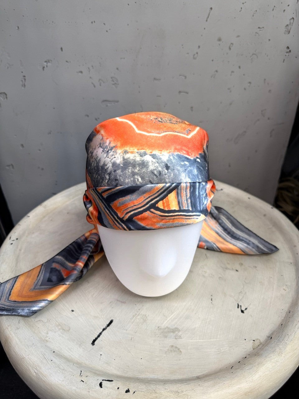 BERLIN VINTAGE CORNER silk scarf with abstract geode print in burnt orange, charcoal, and cream on a mannequin head