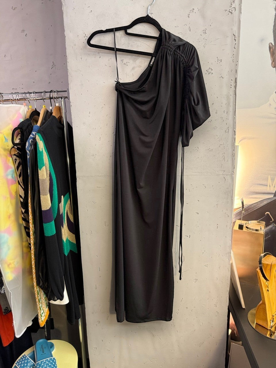 BERLIN VINTAGE CORNER Balmain black one-shoulder midi dress with ruched sleeve detail hanging on a rack.