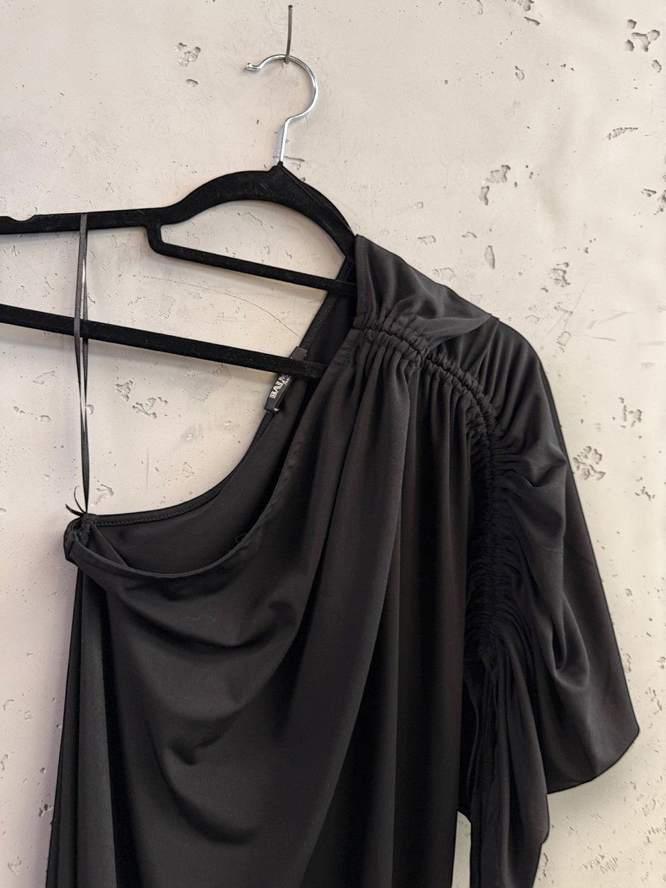 BERLIN VINTAGE CORNER Balmain black one-shoulder midi dress with ruched sleeve detail on a hanger.