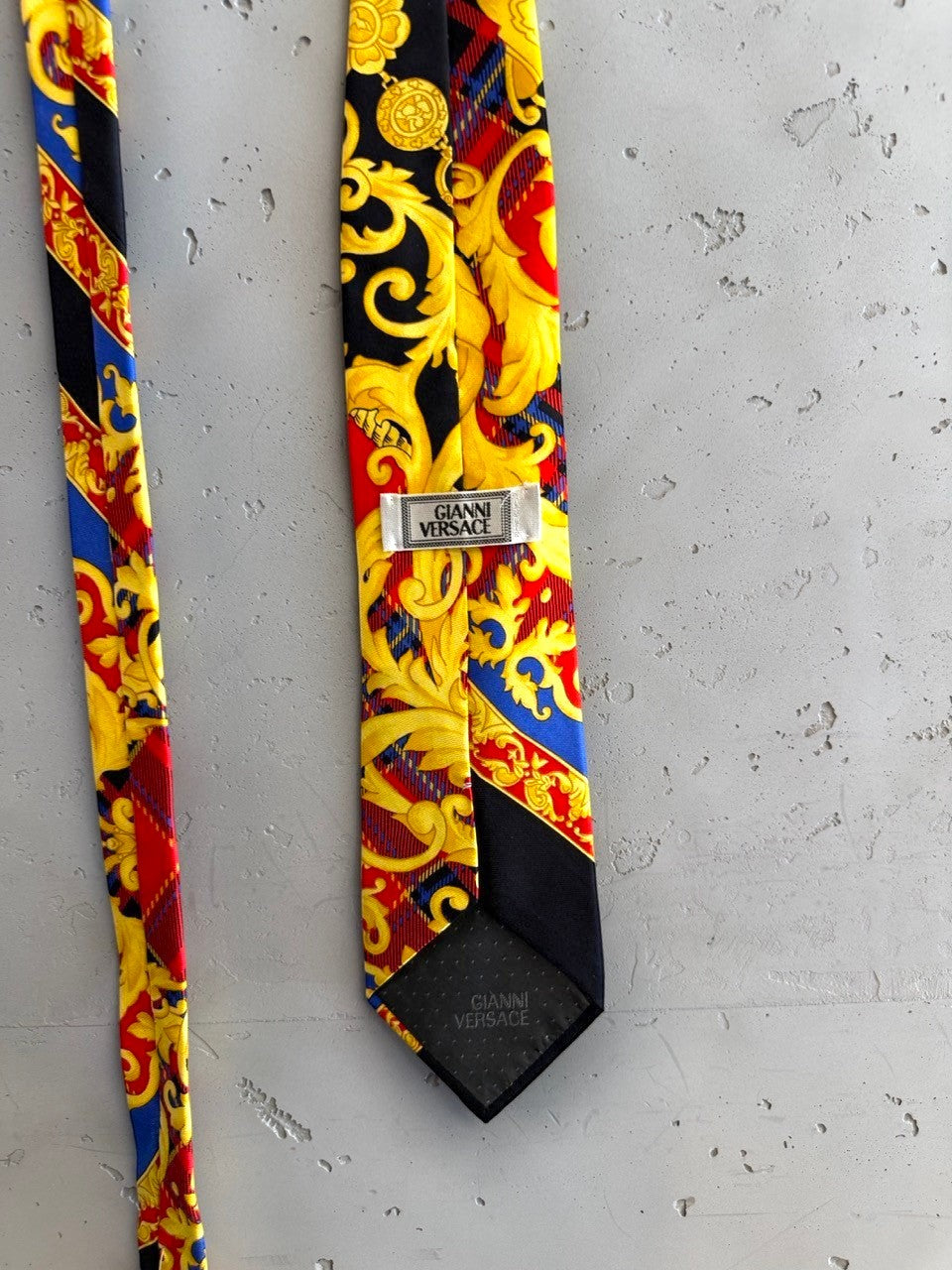BERLIN VINTAGE CORNER black silk skinny tie with gold, red, and blue baroque pattern.