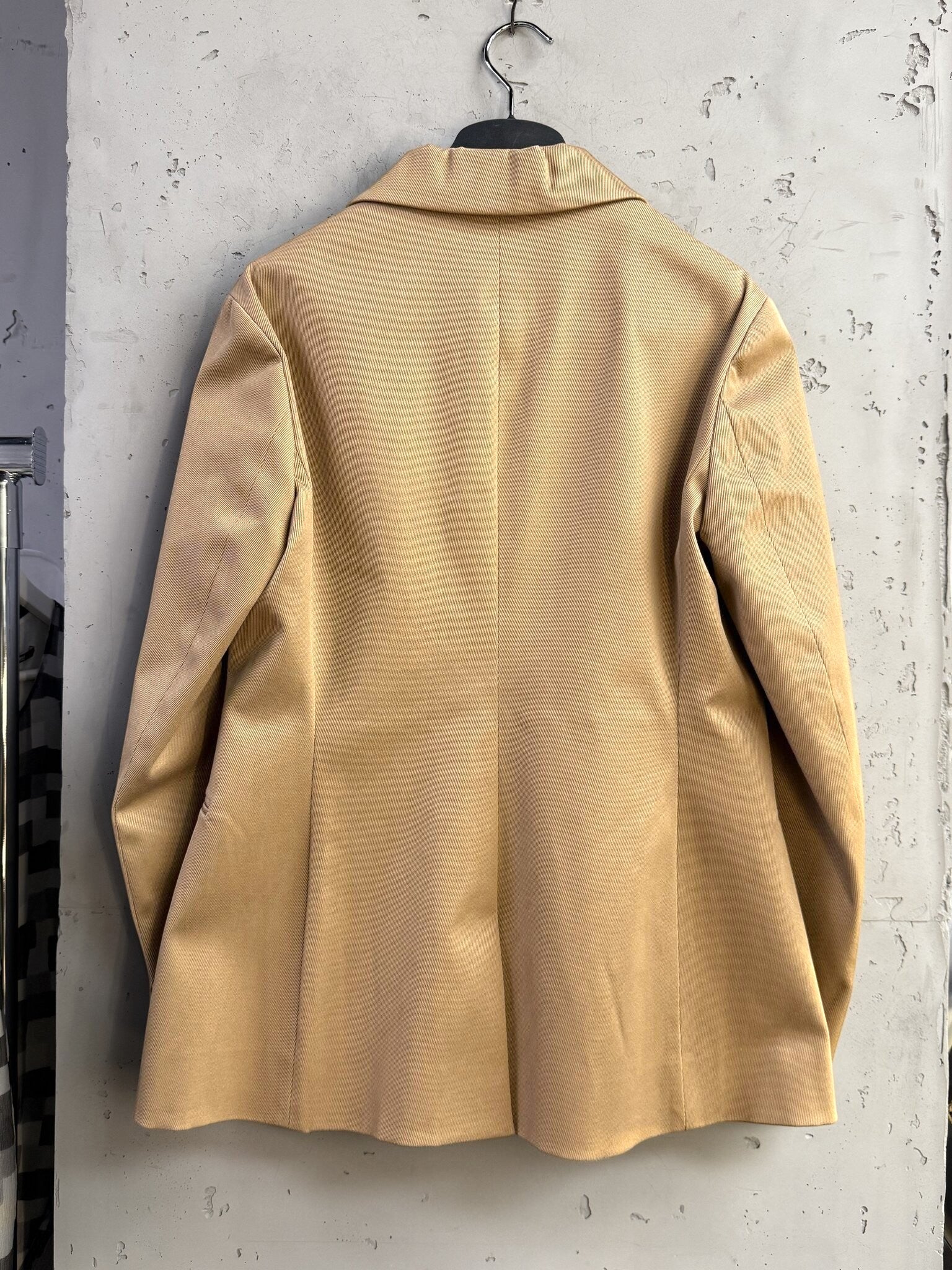 Back view of a beige Christian Dior Paris tailored blazer from BERLIN VINTAGE CORNER, featuring a structured fit.
