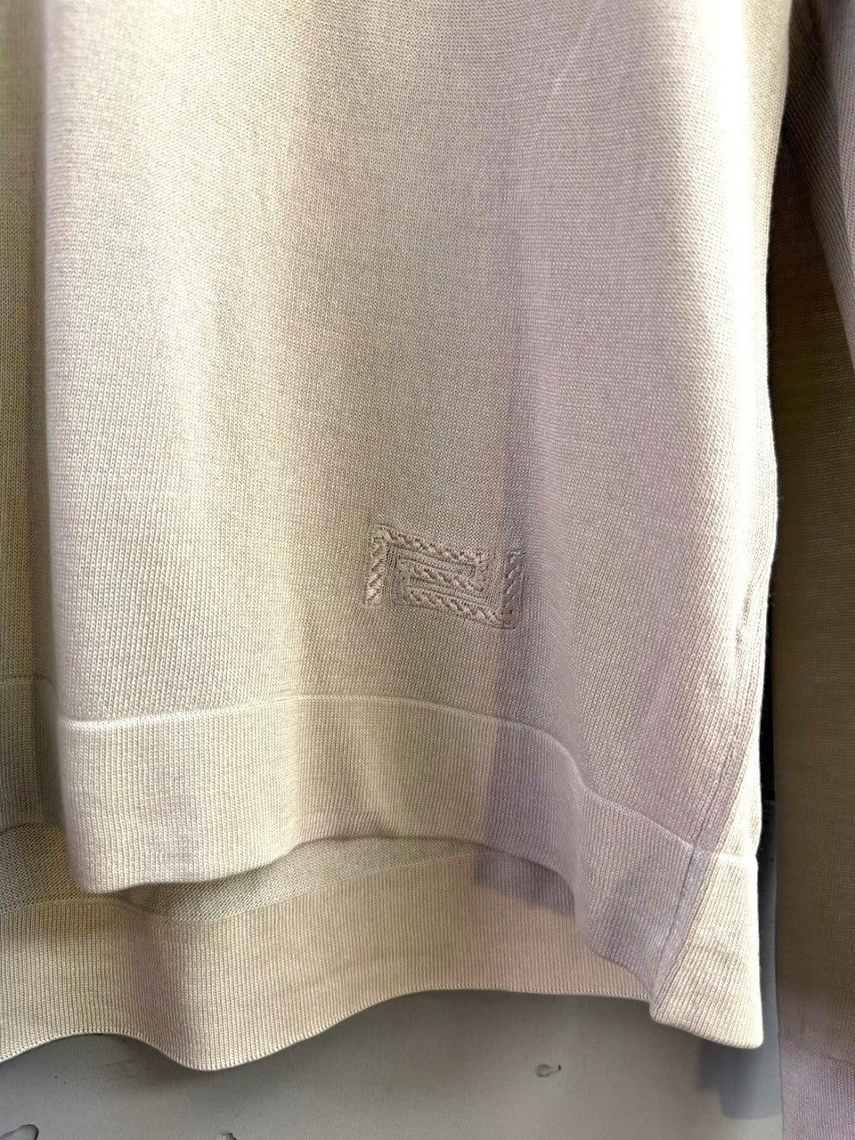 BERLIN VINTAGE CORNER beige knit long sleeve collared shirt with subtle embroidered logo detail and ribbed cuffs and hem.