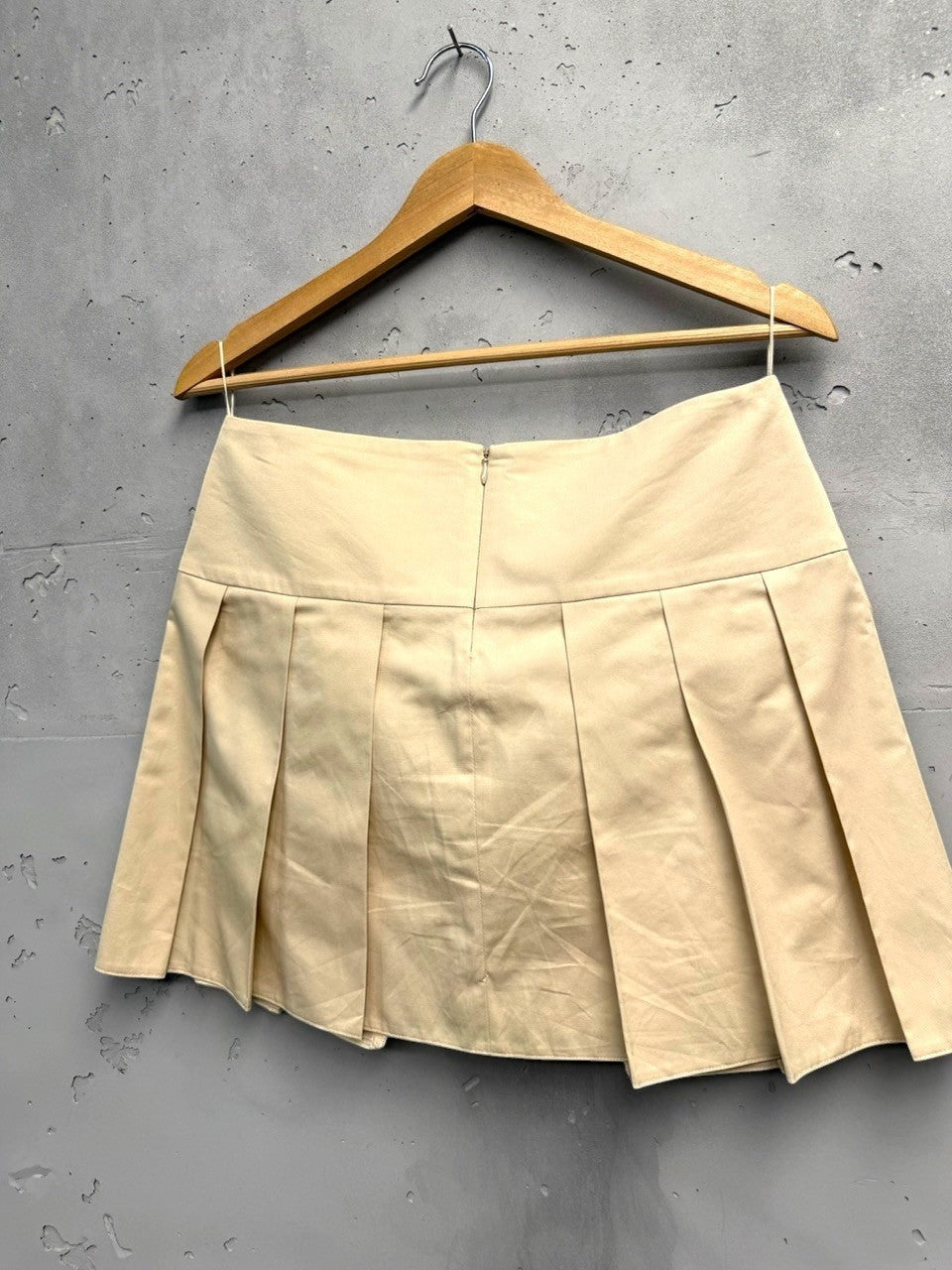 BERLIN VINTAGE CORNER beige cotton blend A-line mini skirt with pleats and pocket detail.