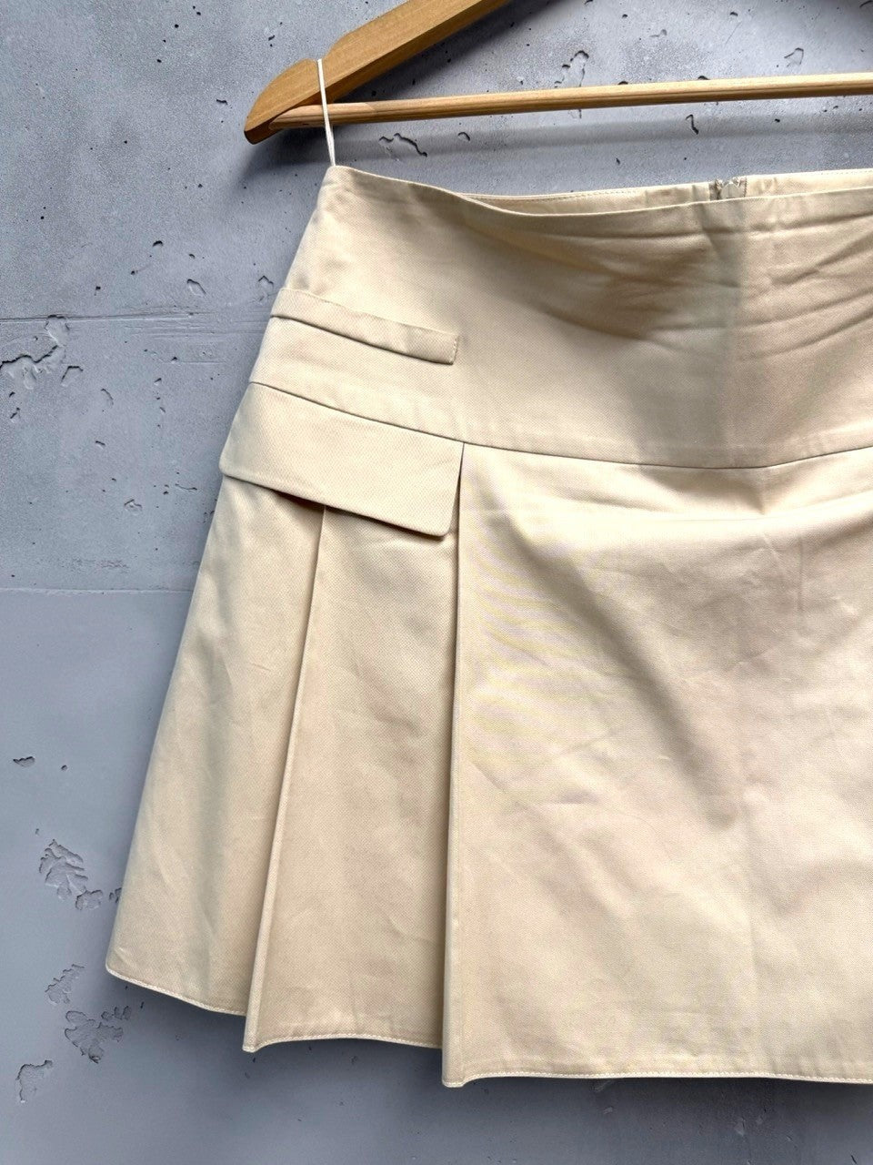 BERLIN VINTAGE CORNER beige cotton blend pleated mini skirt with pocket detail and A-line silhouette.