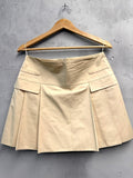 BERLIN VINTAGE CORNER beige cotton blend A-line mini skirt with pleats and pocket detail.