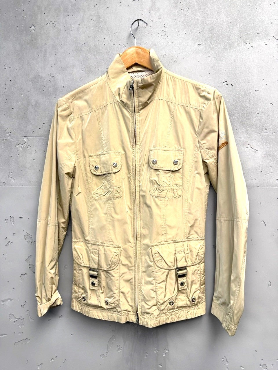 BERLIN VINTAGE CORNER beige lightweight utility jacket with multiple cargo pockets, stand-up collar, and zip closure.