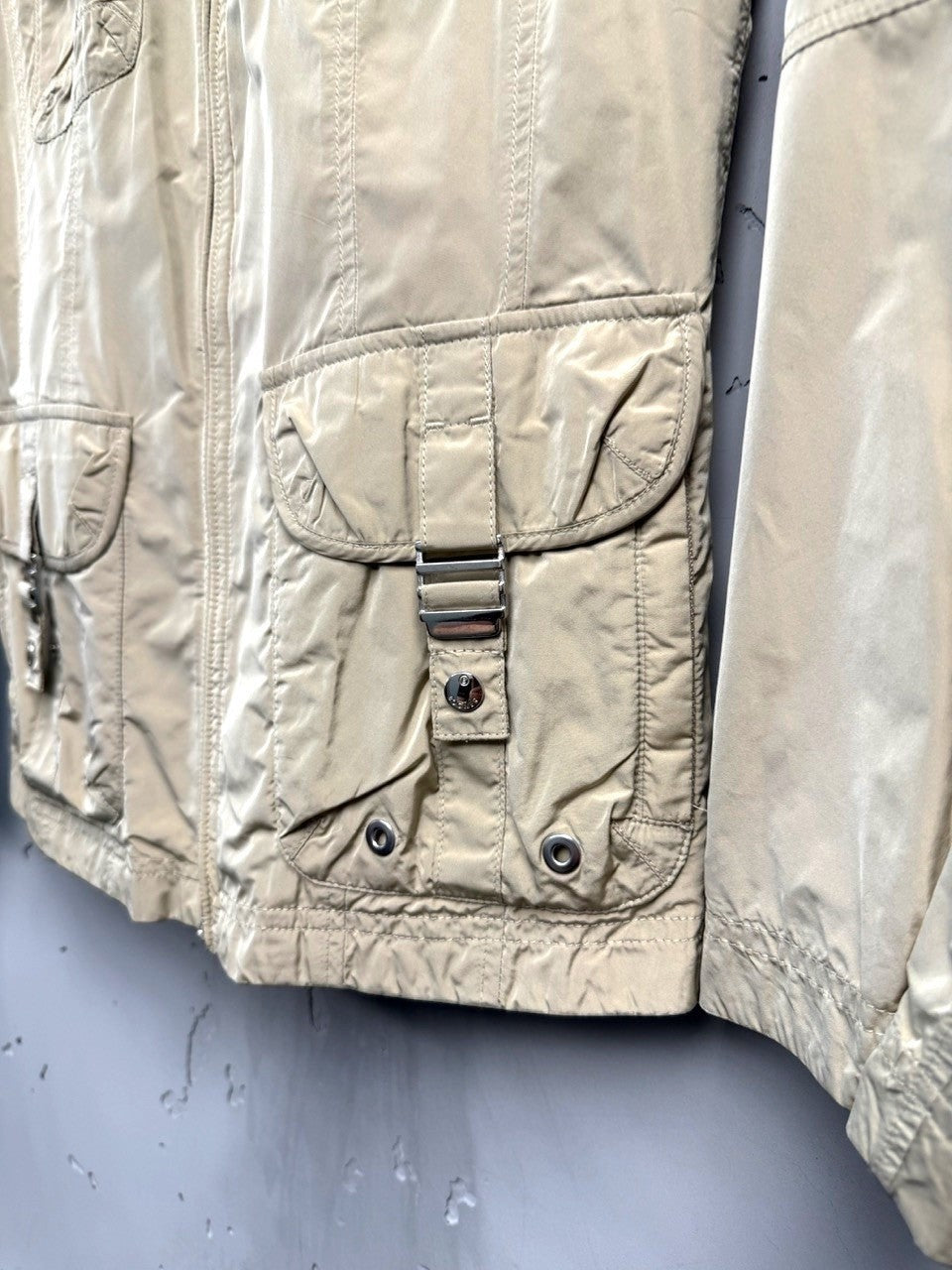 BERLIN VINTAGE CORNER beige lightweight utility jacket with multiple cargo pockets and buckle closures.
