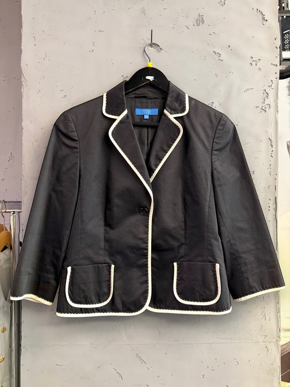 BERLIN VINTAGE CORNER black cropped blazer with white piping on lapels, pockets, and hem. Features single-button closure and 3/4 sleeves.