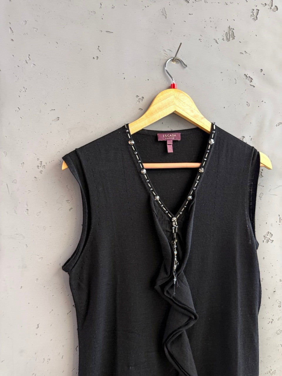BERLIN VINTAGE CORNER black sleeveless knit V-neck top with crystal and bead embellishments and ruffled front.