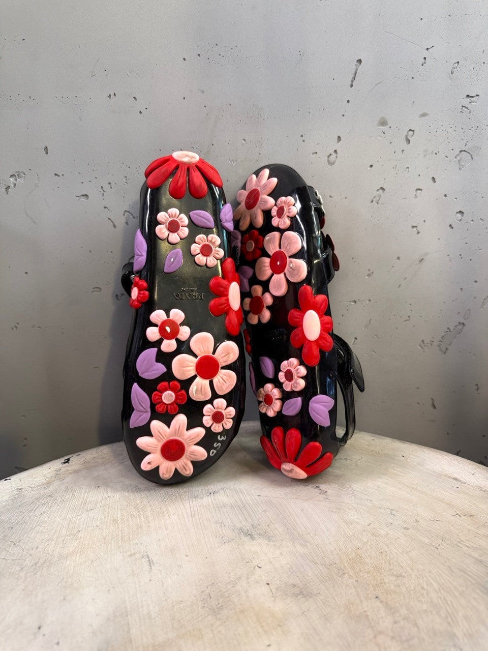 BERLIN VINTAGE CORNER black jelly sandals with red, pink, and purple floral appliqués and lilac leaves. Open toe with ankle strap.