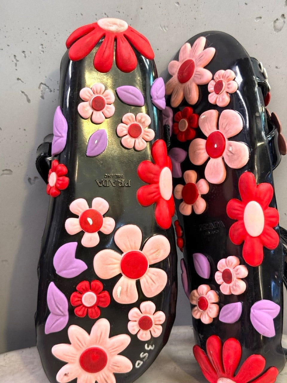 BERLIN VINTAGE CORNER black jelly sandals with red, pink, and purple floral appliqués and lilac leaves. Open-toe design with ankle strap.
