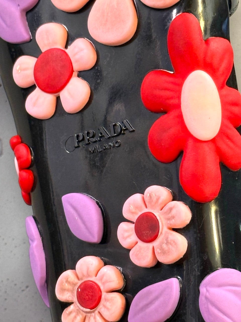 BERLIN VINTAGE CORNER black jelly sandals with red, pink, and purple flower appliqués and lilac leaves.