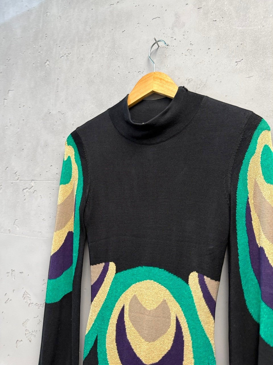 BERLIN VINTAGE CORNER black knit dress with high neckline, long sleeves, and retro geometric pattern in emerald green, purple, and gold.