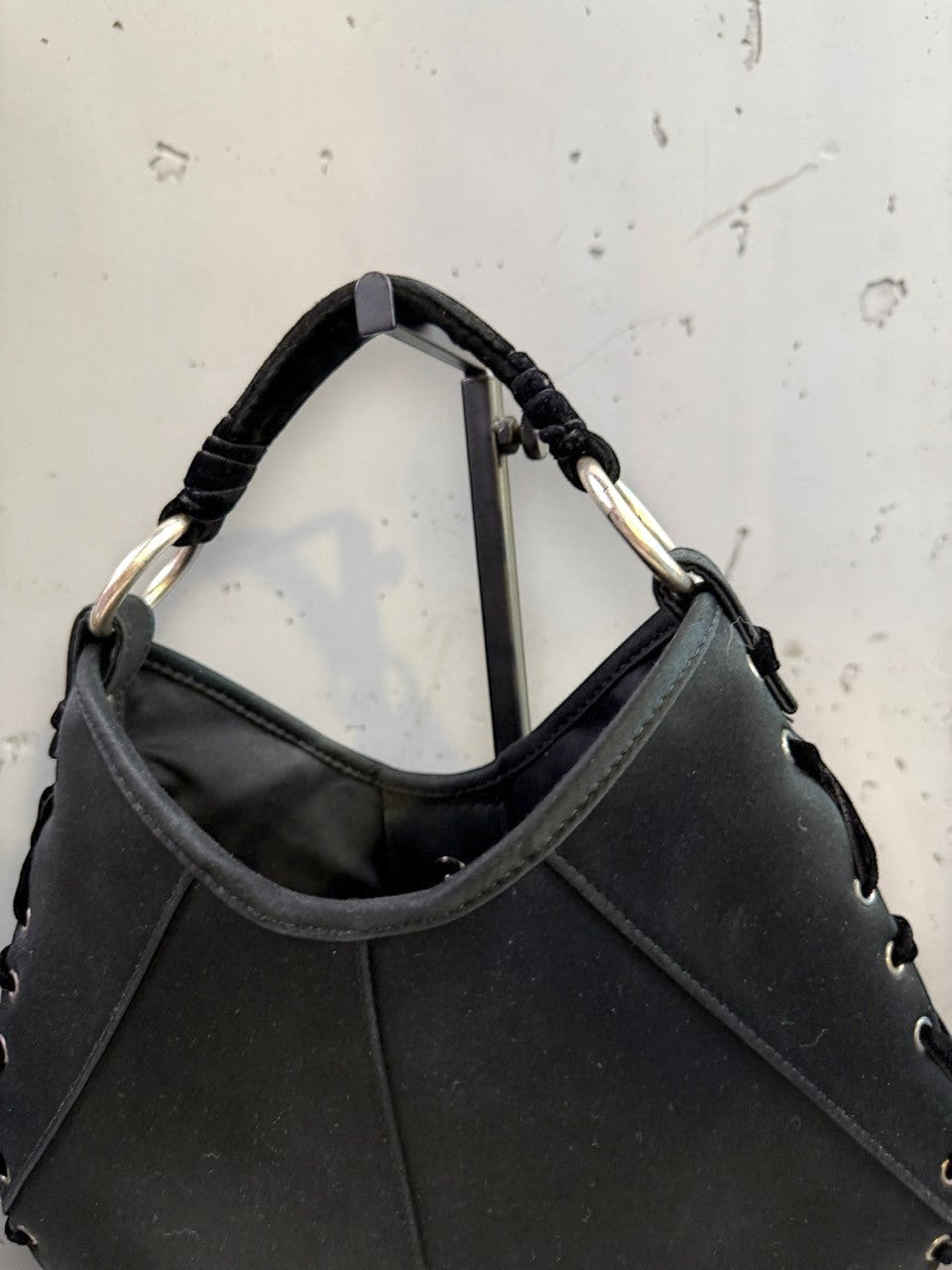 BERLIN VINTAGE CORNER black hobo shoulder bag with velvet strap and silver O-ring accents, featuring lacing detail.
