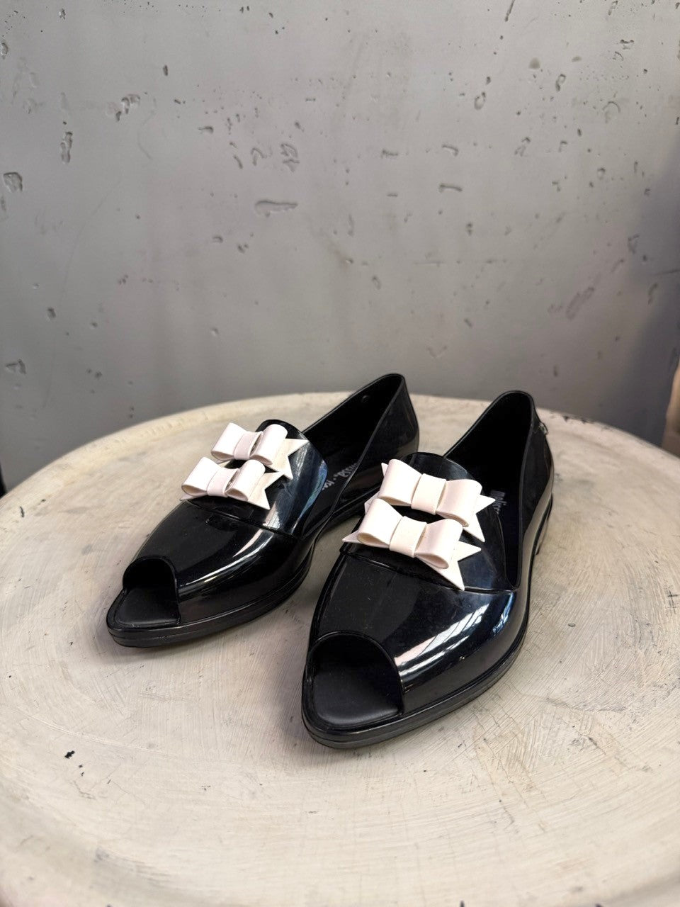 BERLIN VINTAGE CORNER black PVC jelly loafers with peep toe and pale pink double bow accent.