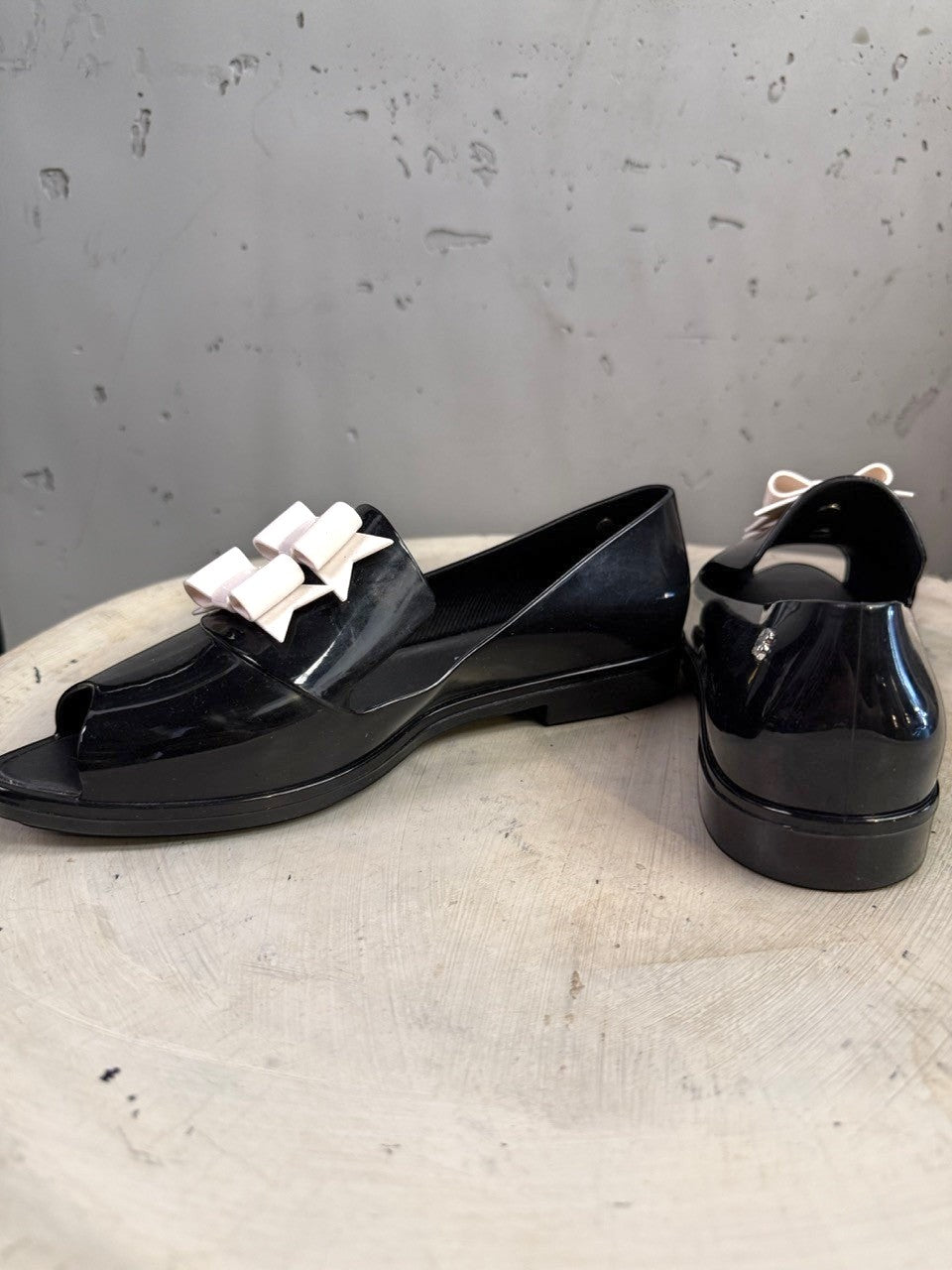 BERLIN VINTAGE CORNER black PVC jelly loafers with peep toe and pale pink double bow accent.