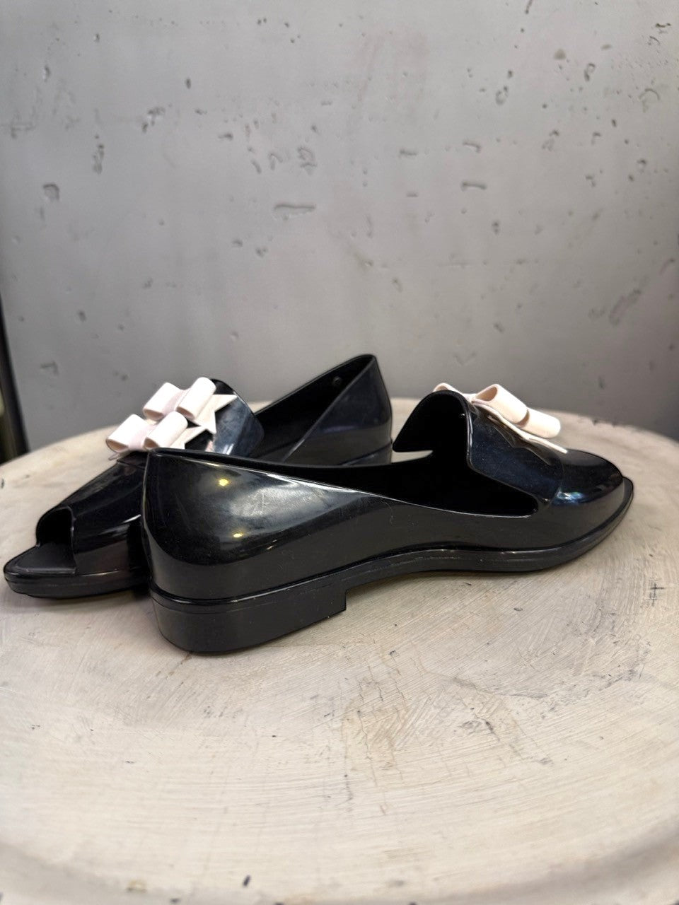 BERLIN VINTAGE CORNER black PVC jelly loafers with pale pink double bow accent and peep-toe design.