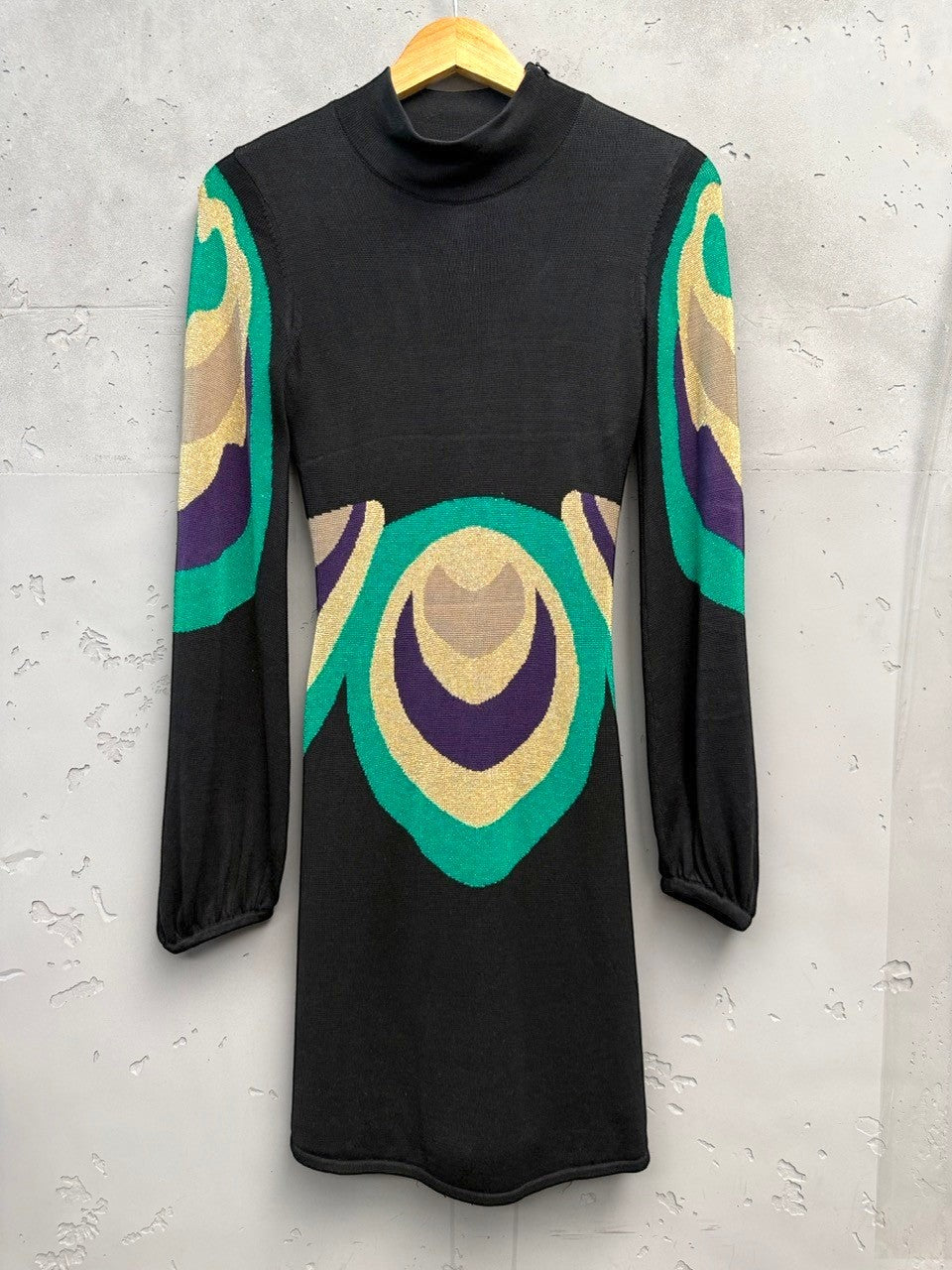 BERLIN VINTAGE CORNER black knit dress with high neck, long sleeves, and retro geometric pattern in green, purple, and gold.