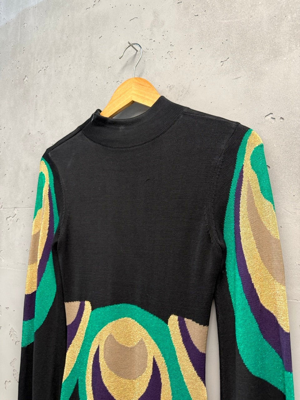 BERLIN VINTAGE CORNER black knit dress with high neck, long sleeves, and retro geometric pattern in green, purple, and gold.