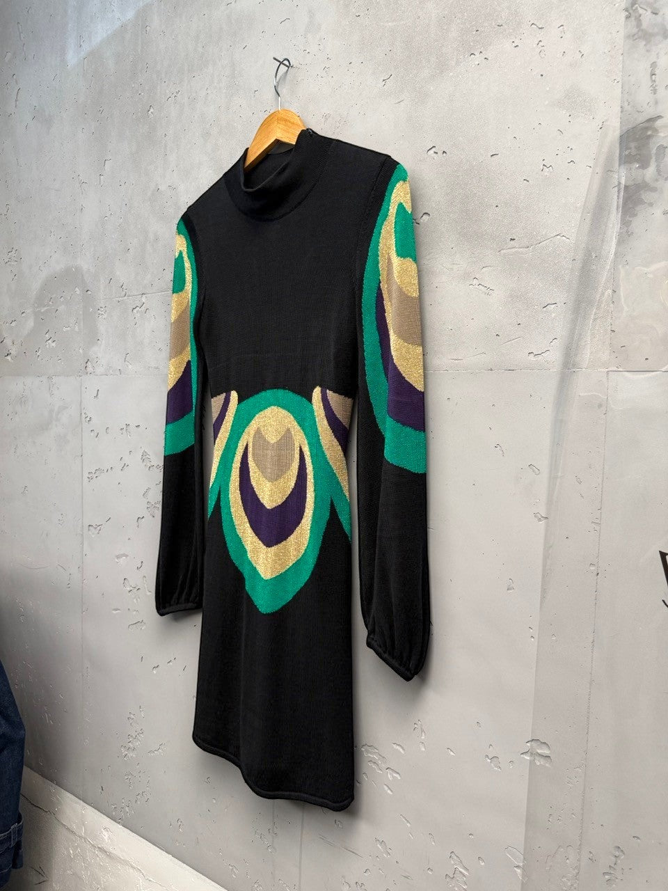 BERLIN VINTAGE CORNER black knit dress with high neckline, long sleeves, and a bold geometric pattern in emerald green, purple, and gold.