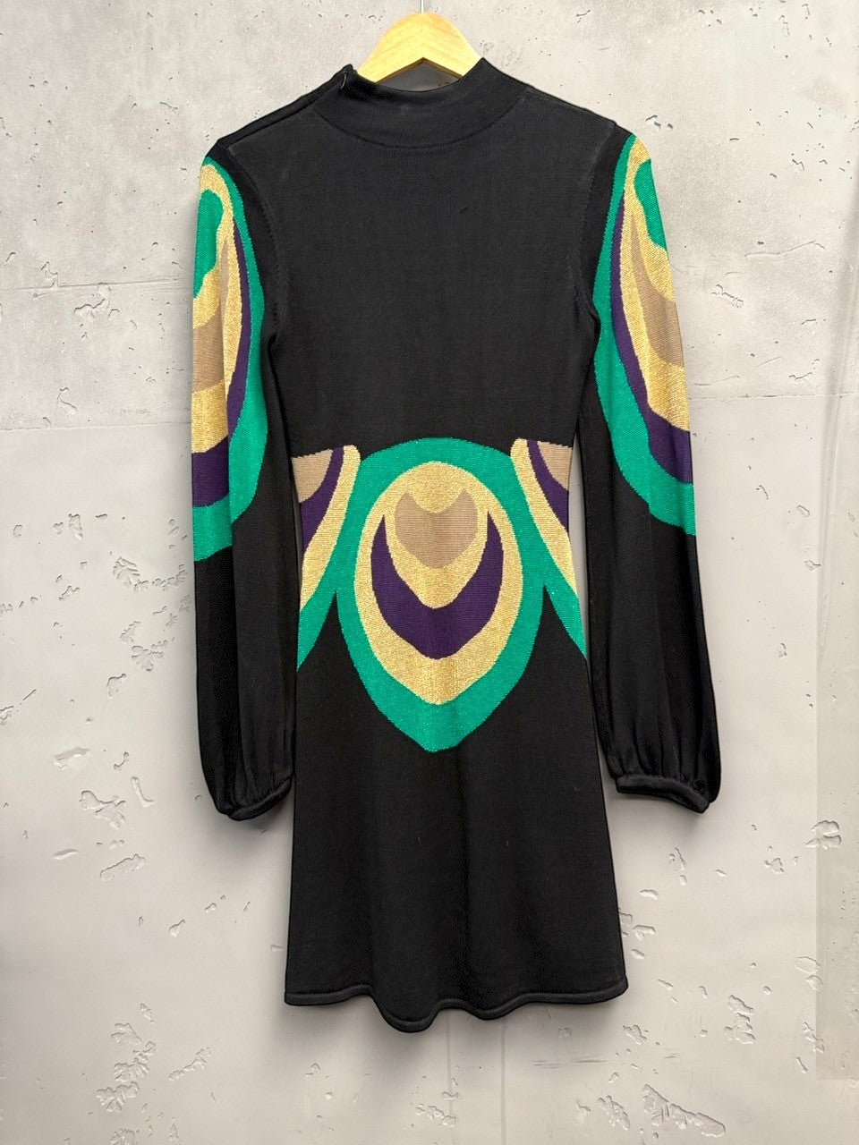 BERLIN VINTAGE CORNER black knit dress with high neckline, long sleeves, and retro geometric pattern in green, purple, and gold.