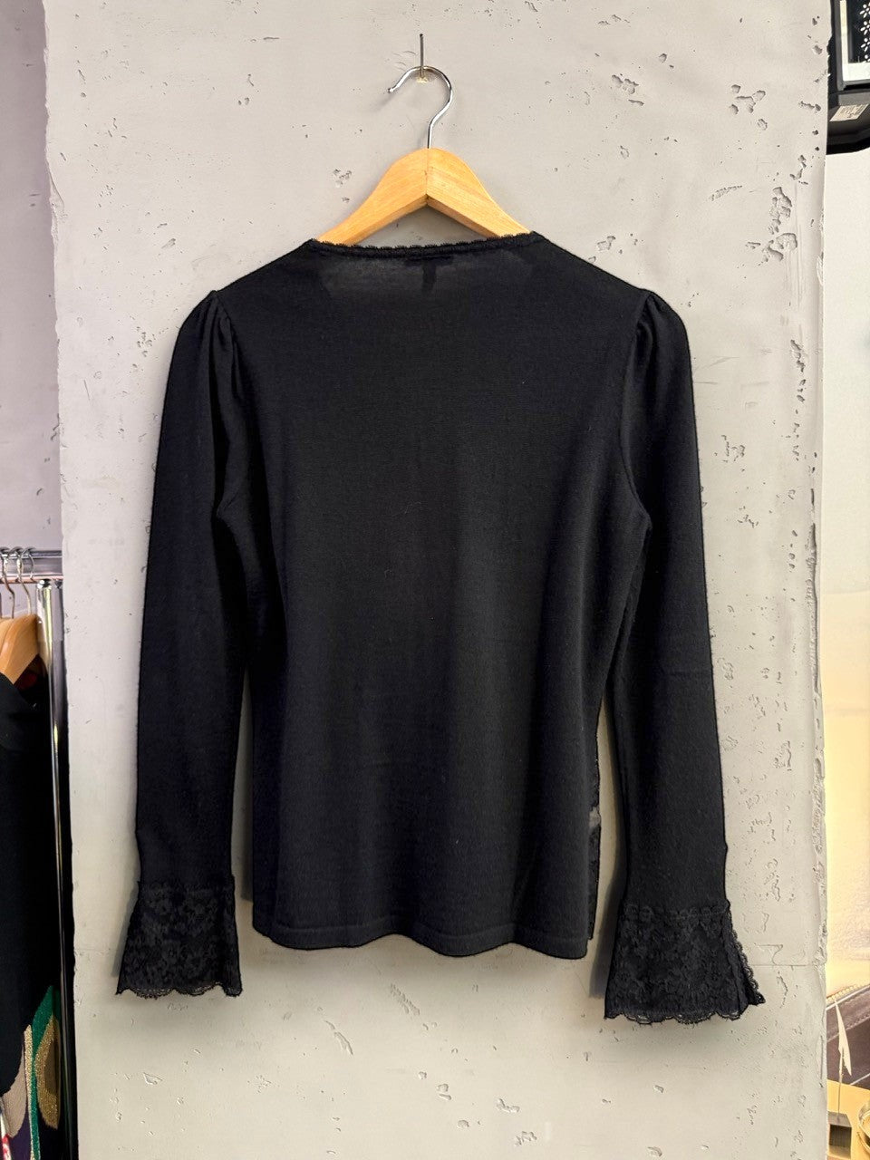 BERLIN VINTAGE CORNER black long sleeve knit top with lace trim on neckline and flared lace cuffs.