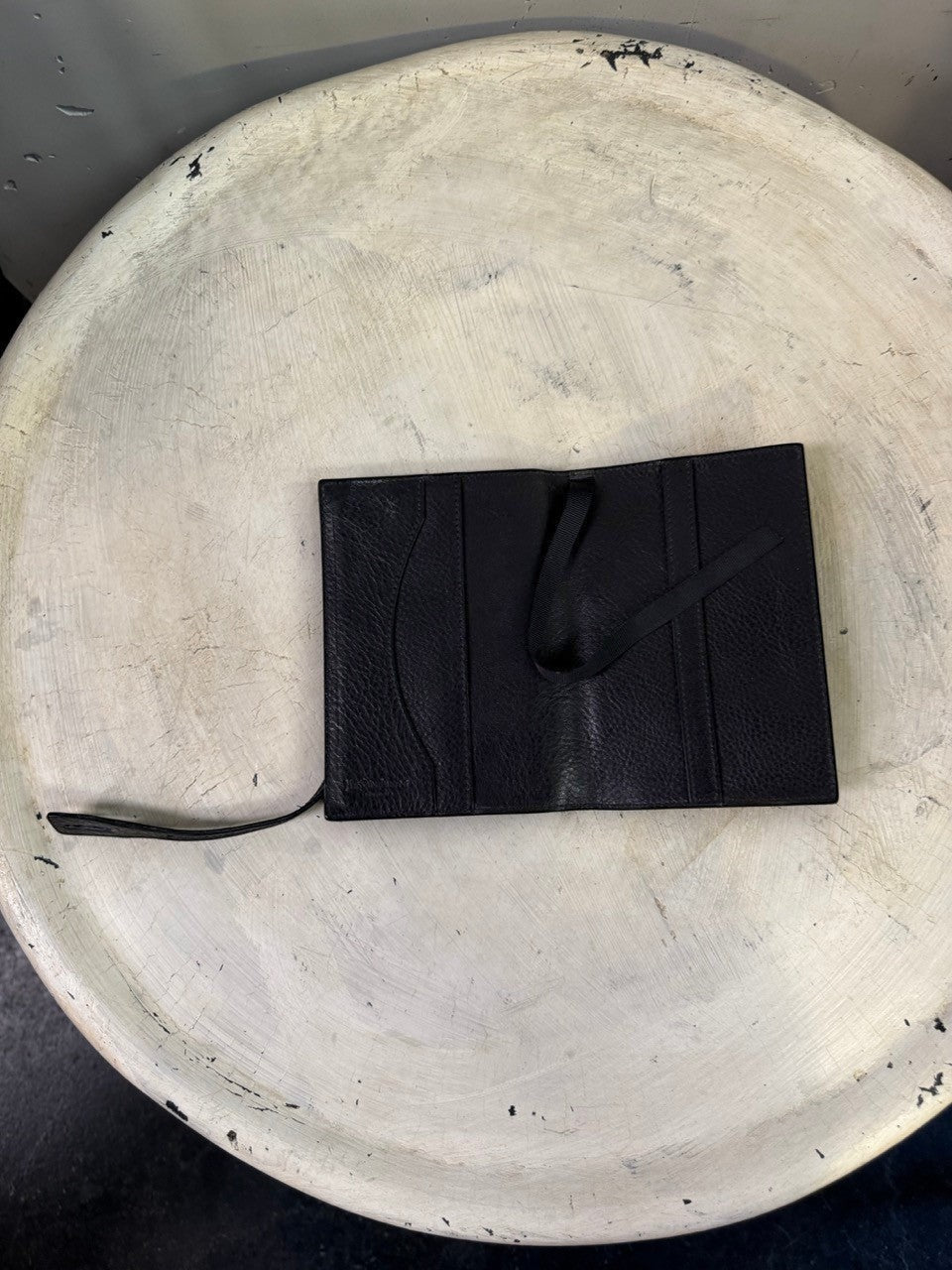BERLIN VINTAGE CORNER black leather card holder with strap and snap closure.