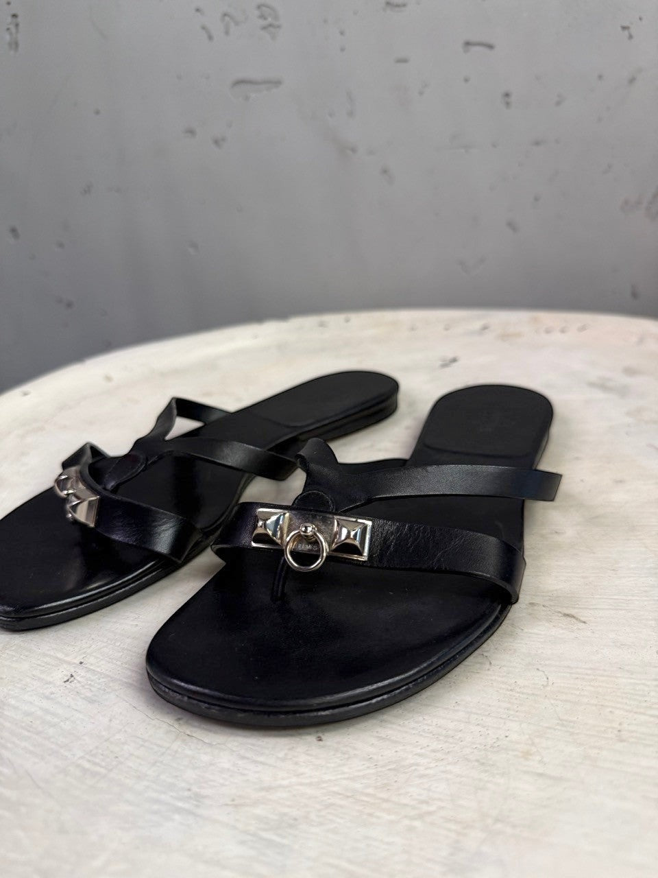 BERLIN VINTAGE CORNER black leather thong sandals featuring iconic metallic hardware and a sleek minimalist design.