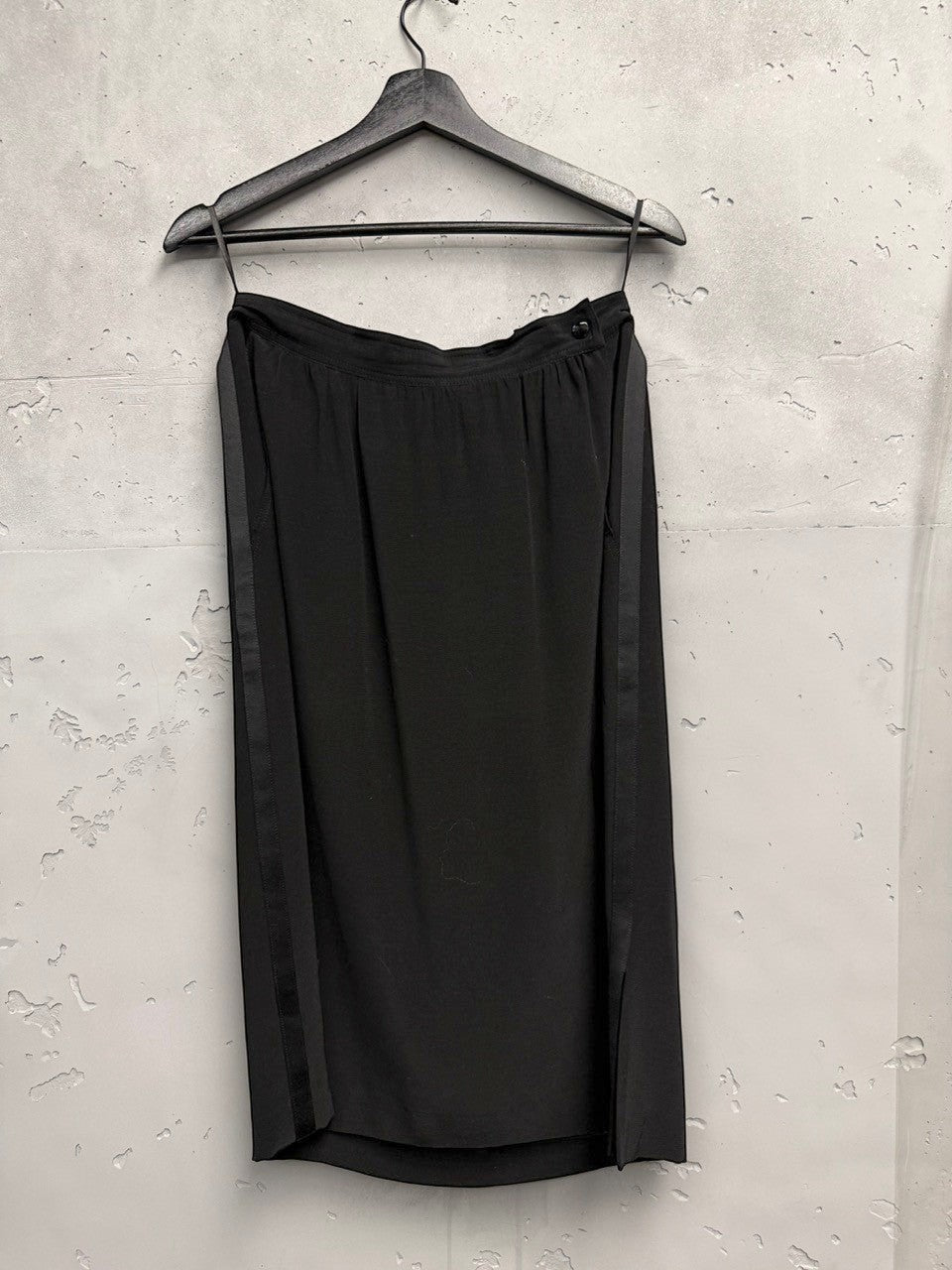 BERLIN VINTAGE CORNER black midi skirt with satin side panels and button closure, flowing fabric.