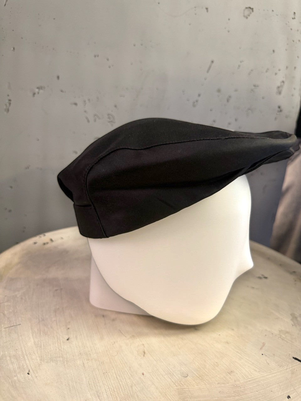 BERLIN VINTAGE CORNER black newsboy cap on a mannequin head, featuring a structured silhouette and classic design.