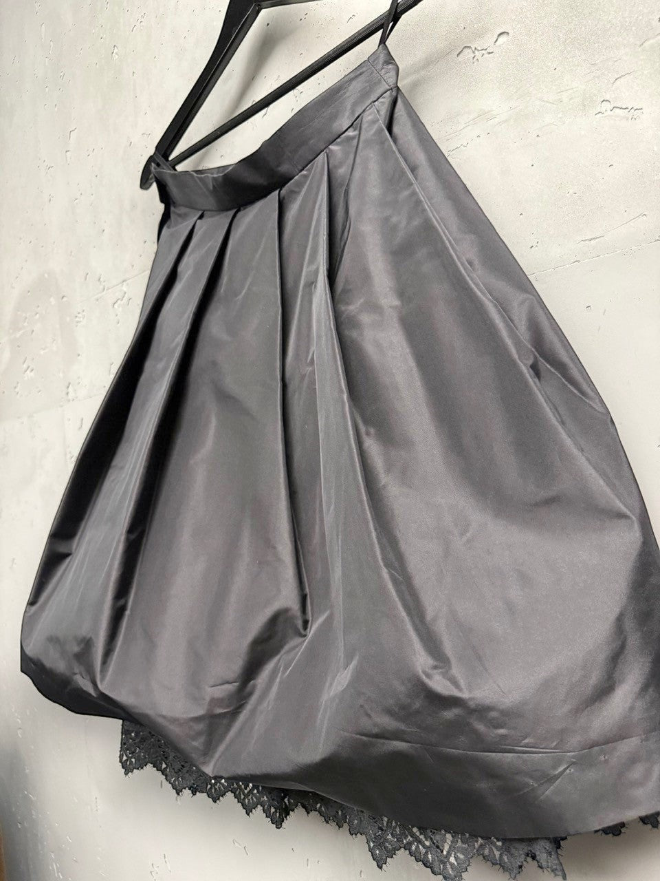 BERLIN VINTAGE CORNER black midi skirt with pleats and lace trim, satin-like fabric, A-line silhouette, tulle layer for volume.