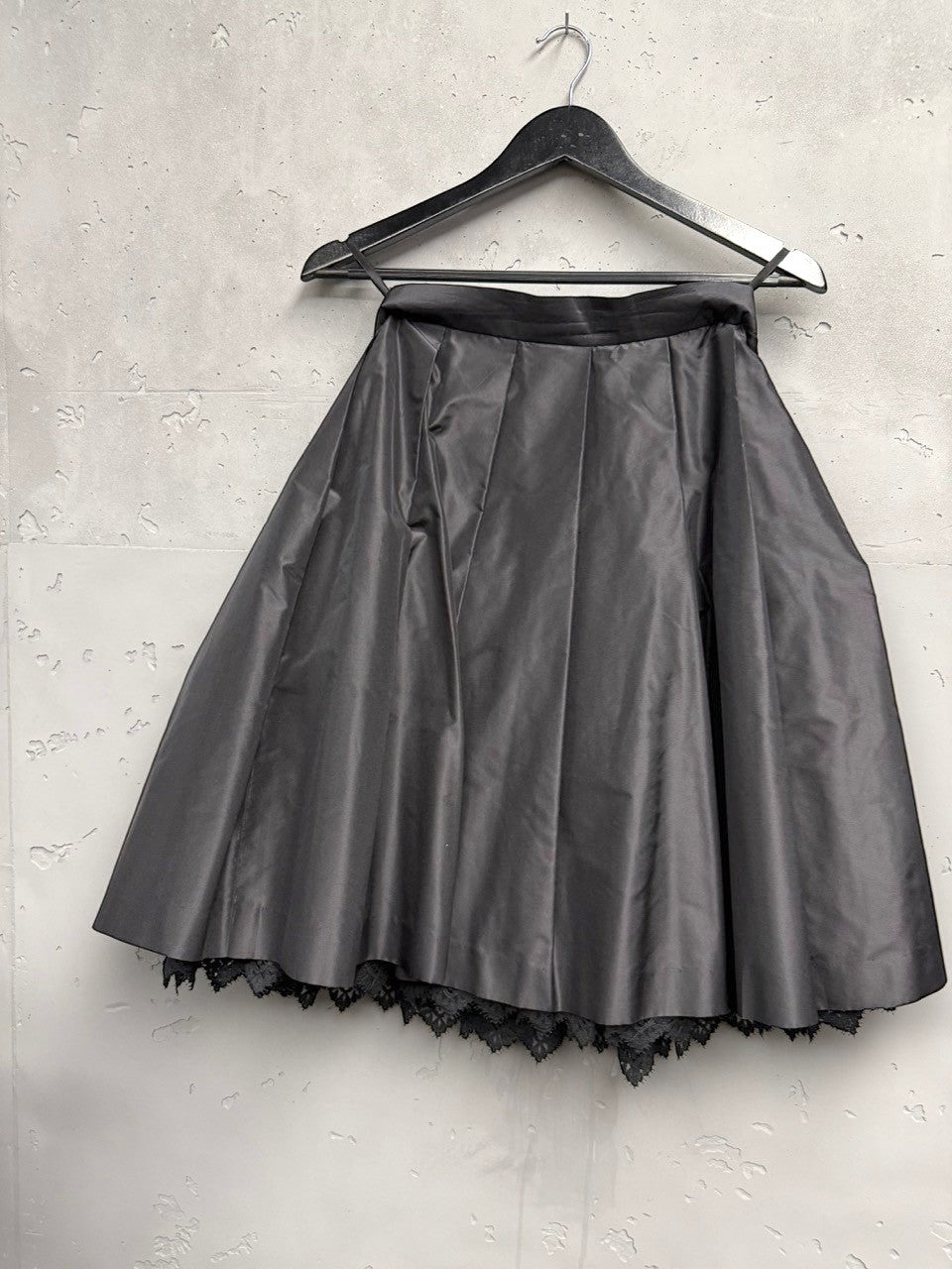 BERLIN VINTAGE CORNER black midi skirt with pleats and lace trim, satin-like fabric, A-line silhouette, tulle layer for volume.