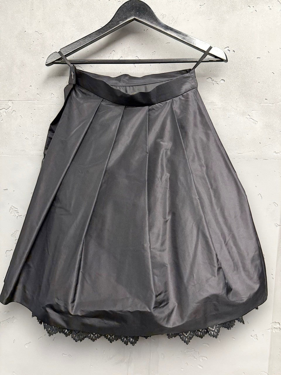 BERLIN VINTAGE CORNER black satin-like midi skirt with pleats and lace trim hem, A-line silhouette.