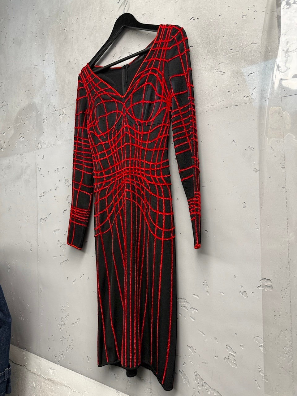 BERLIN VINTAGE CORNER black knit midi dress with a bold red geometric grid pattern, V-neckline, and long sleeves.