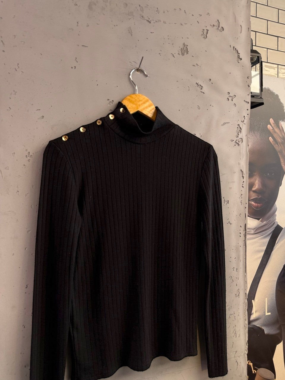 BERLIN VINTAGE CORNER black ribbed knit mock neck long sleeve top with gold-tone shoulder buttons.