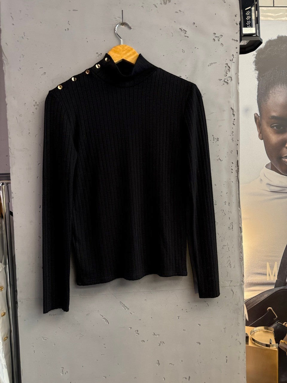BERLIN VINTAGE CORNER black ribbed knit mock neck long sleeve top with gold-tone button details on the shoulder.