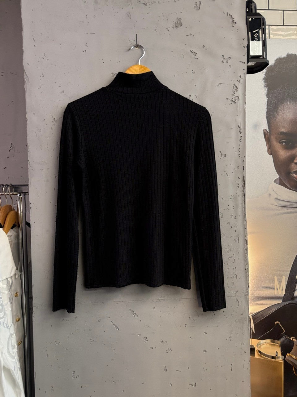 BERLIN VINTAGE CORNER black ribbed mock neck long sleeve top with subtle gold-tone button details on the shoulder.