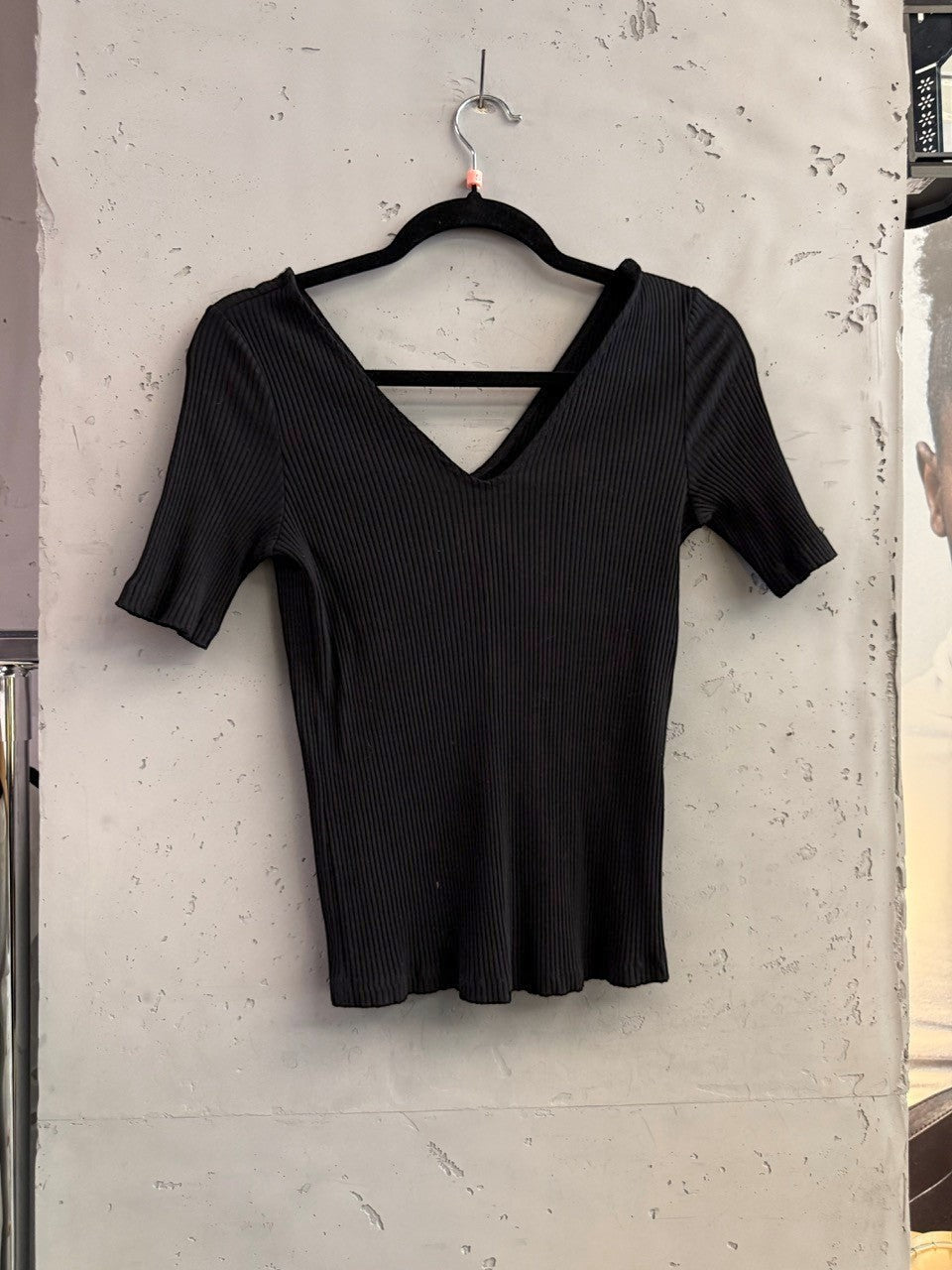 BERLIN VINTAGE CORNER black ribbed V-neck short sleeve knit top with a subtle V-detail at the back.