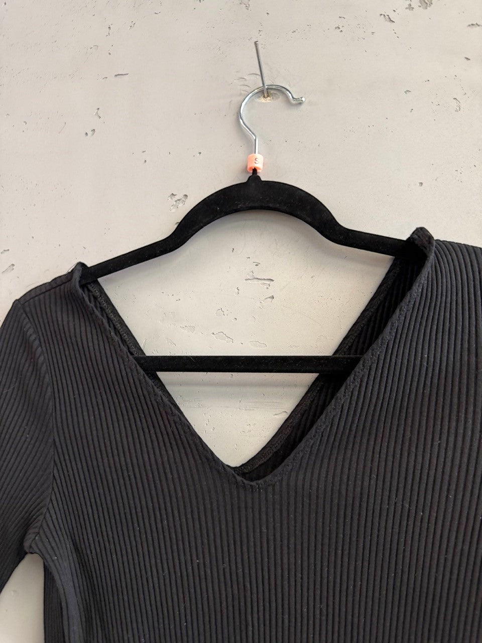 BERLIN VINTAGE CORNER black ribbed V-neck short sleeve knit top with a subtle V-detail at the back.