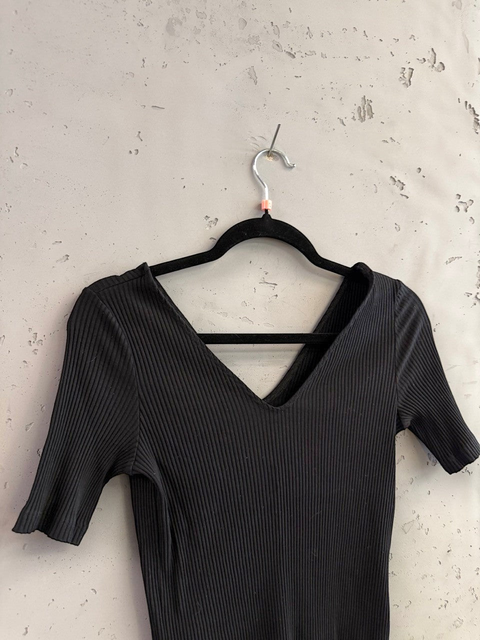 BERLIN VINTAGE CORNER black ribbed V-neck short sleeve top with a criss-cross back detail.