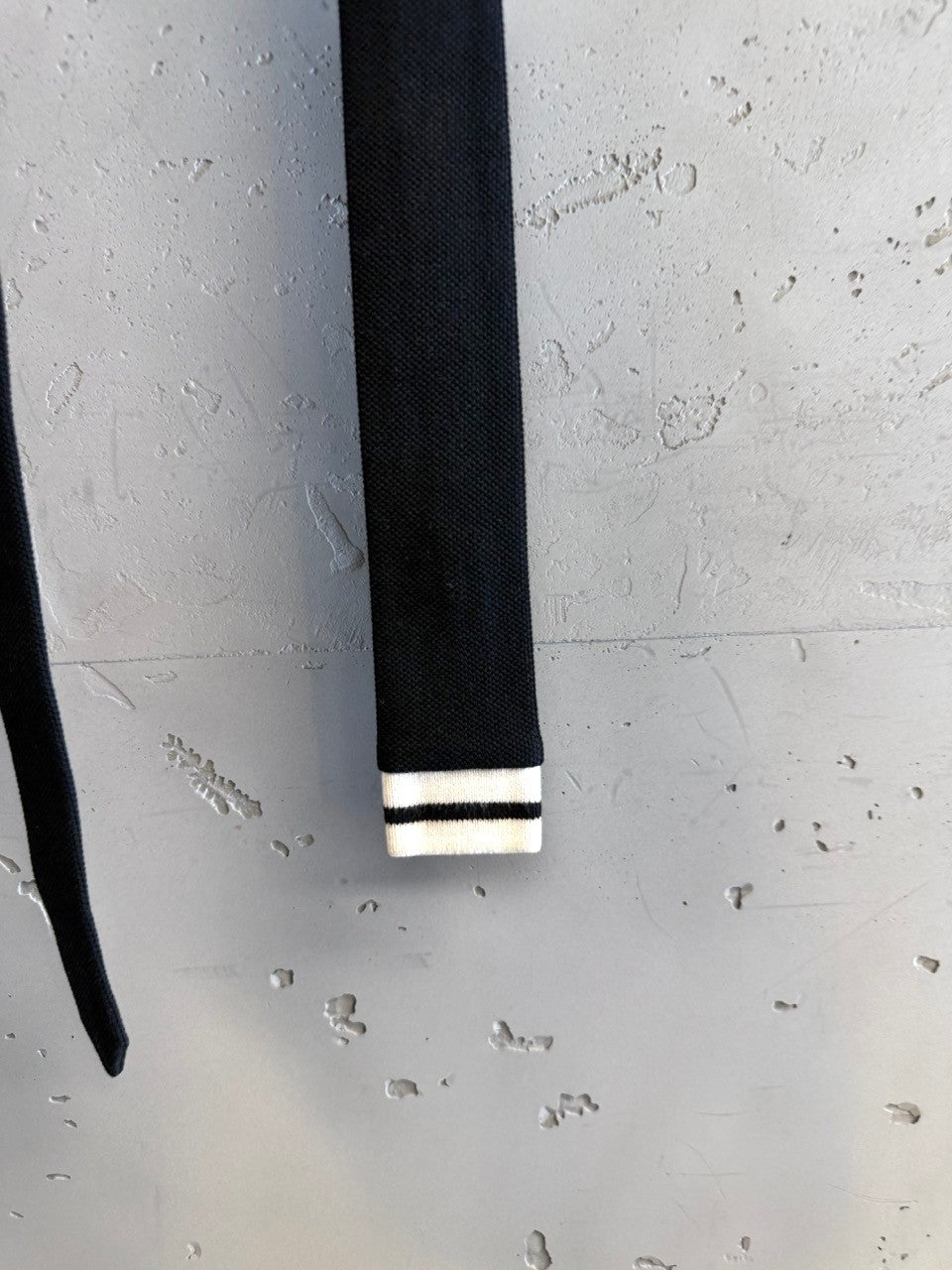 BERLIN VINTAGE CORNER black knit tie with white stripes at the tip. Durable fabric, versatile for formal or casual wear.