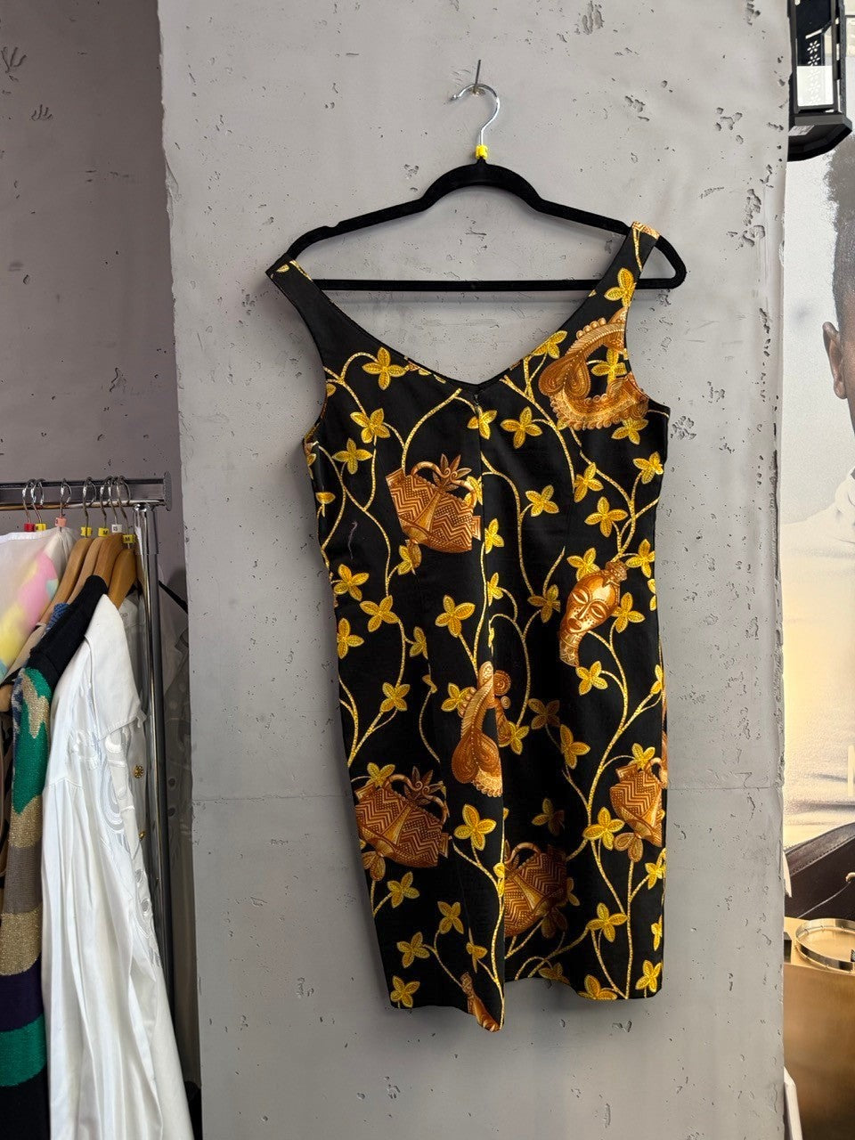 BERLIN VINTAGE CORNER black sleeveless mini dress with gold tribal floral print and V-neckline.