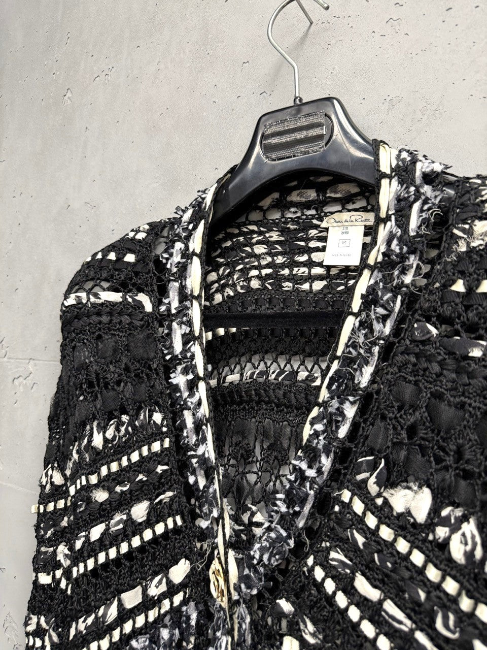 BERLIN VINTAGE CORNER black and white open-weave knit longline cardigan with fringe details and button closure.