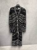 BERLIN VINTAGE CORNER black and white long knit cardigan with open-weave texture, fringe details, and button closures.