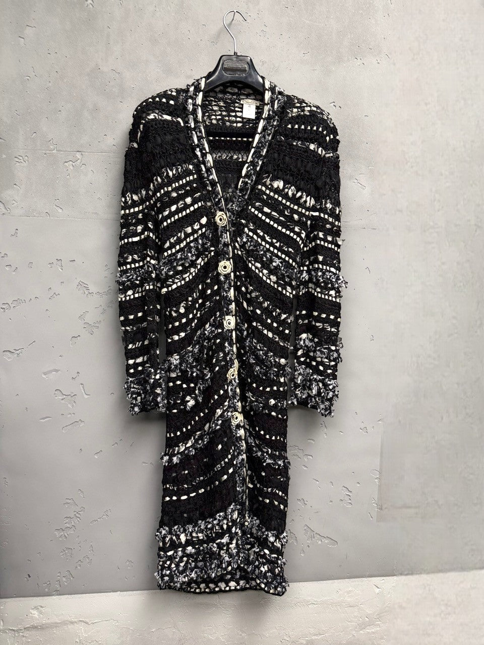 BERLIN VINTAGE CORNER black and white long knit cardigan with open-weave texture, fringe details, and button closures.