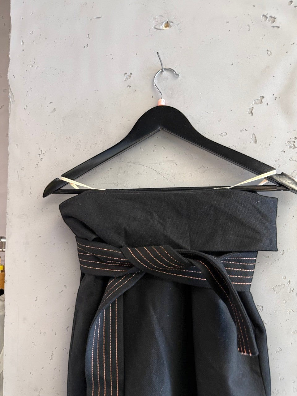 BERLIN VINTAGE CORNER black wool blend wide leg trousers with rose gold stitching detail and wrap belt.
