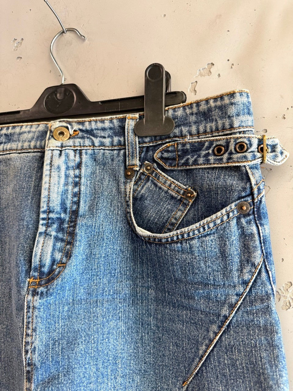 BERLIN VINTAGE CORNER blue denim mini skirt with adjustable buckle waistband and unique pocket design.